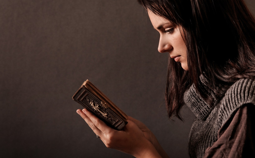 profile of young woman reading the Bible