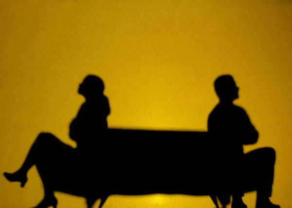 silhouettes of woman and man back to back with arms crossed
