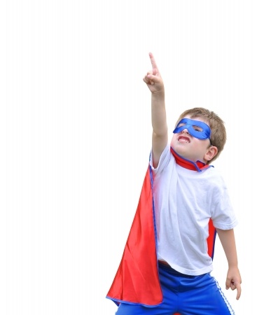 Boy dressed as superheo pointng up