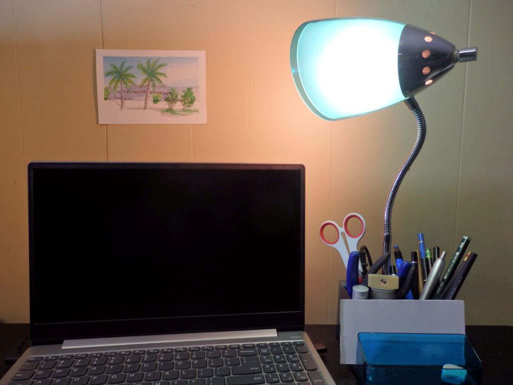 Informative image: Watercolor beach scene hanging over workstation.